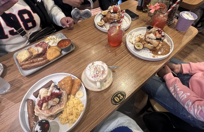 The long shared table busy with brunch plates and drinks