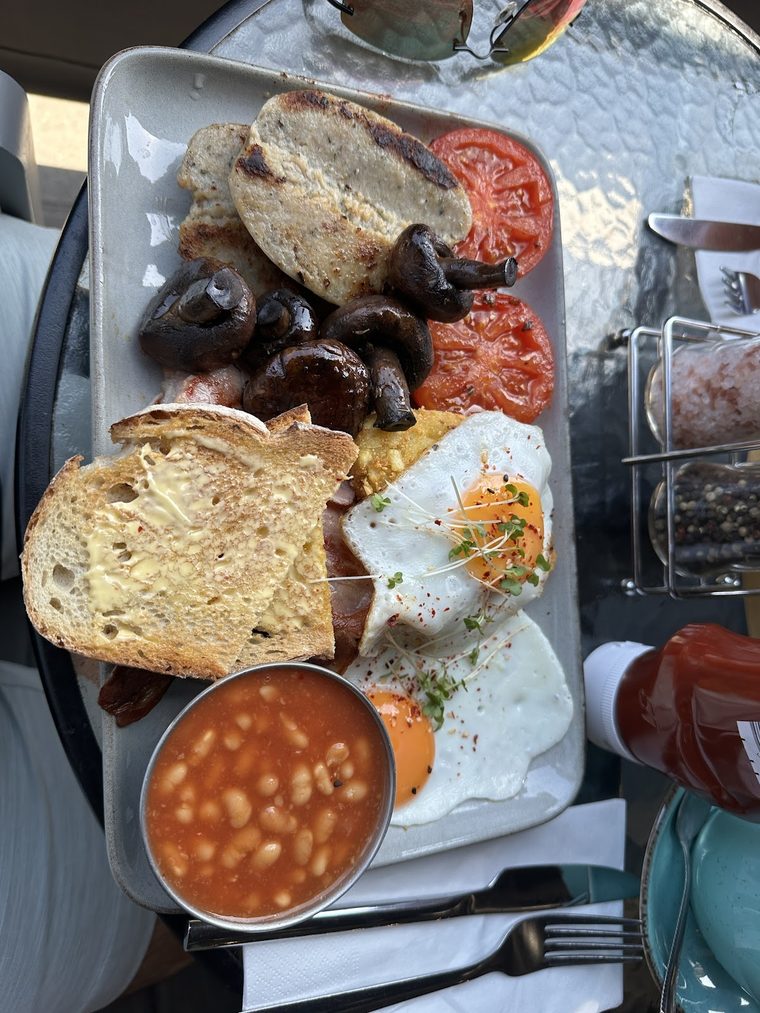 Full English breakfast plate with a pot of baked beans