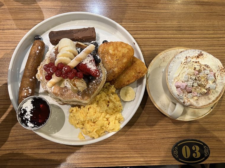 Pancake and cooked breakfast plate with a topped hot chocolate